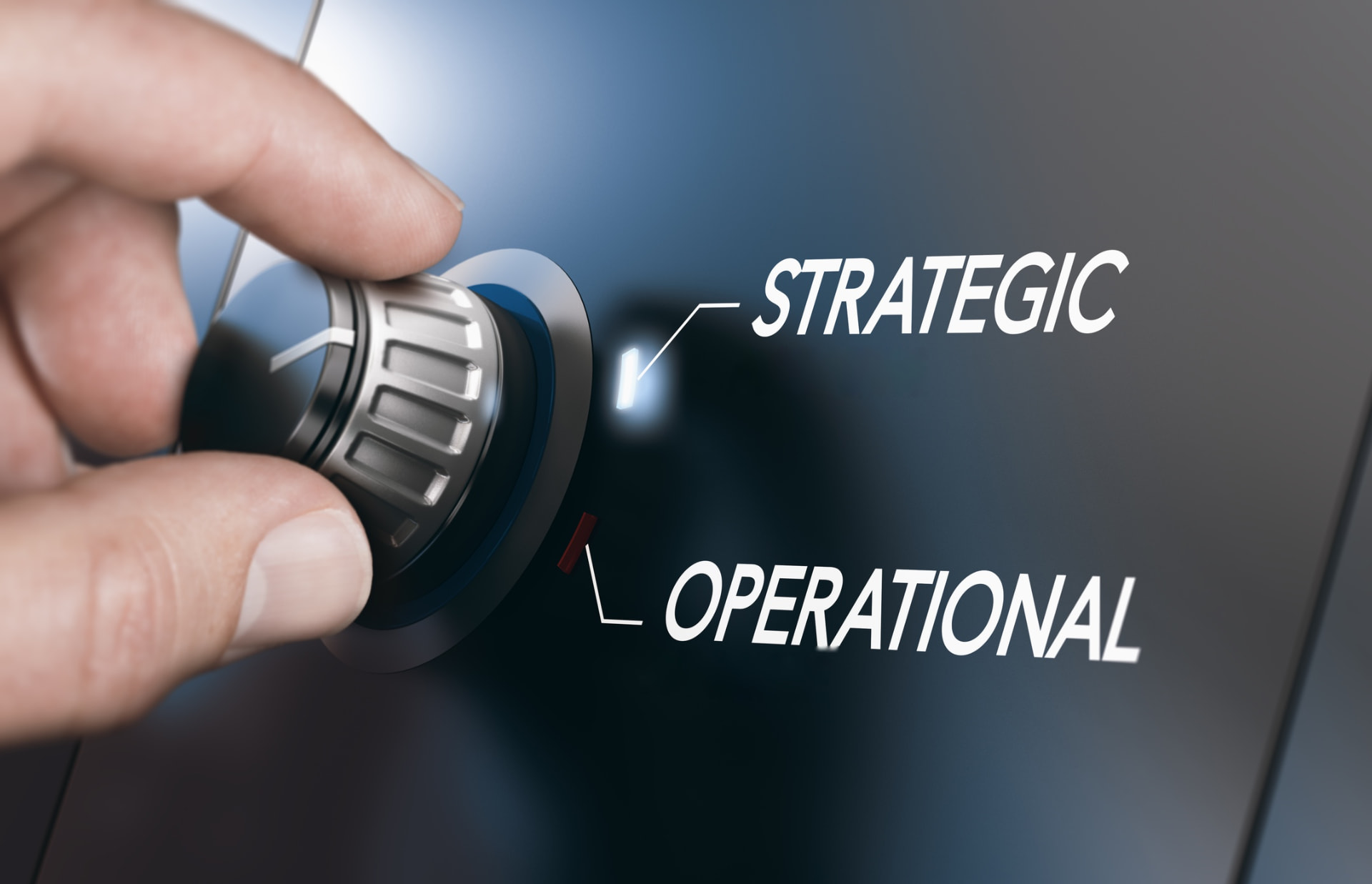Hånd der drejer en kontrolknap mellem indstillingerne Strategic og Operational