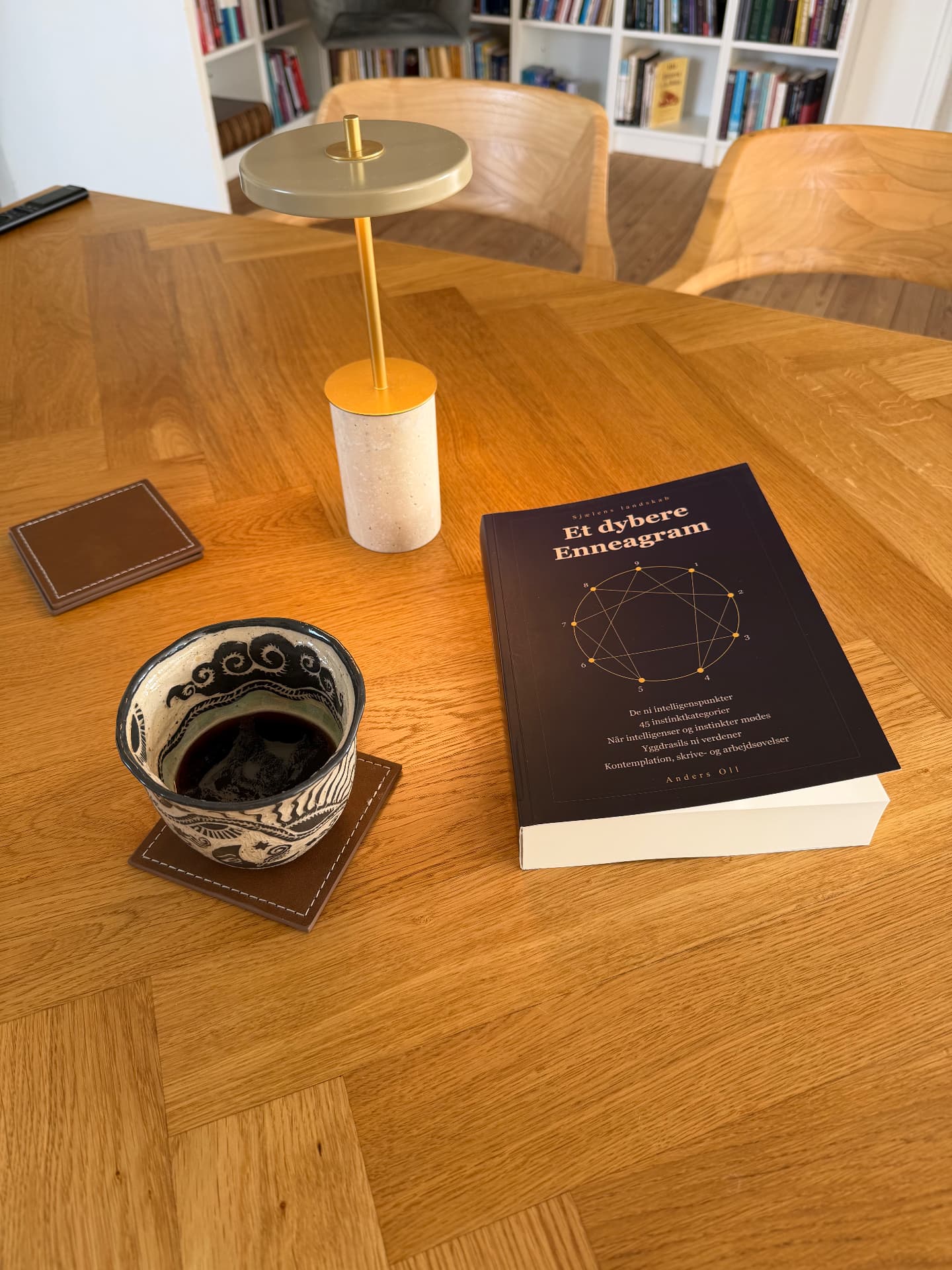 Bogen på bordet ved siden af en kaffekop og en lampe